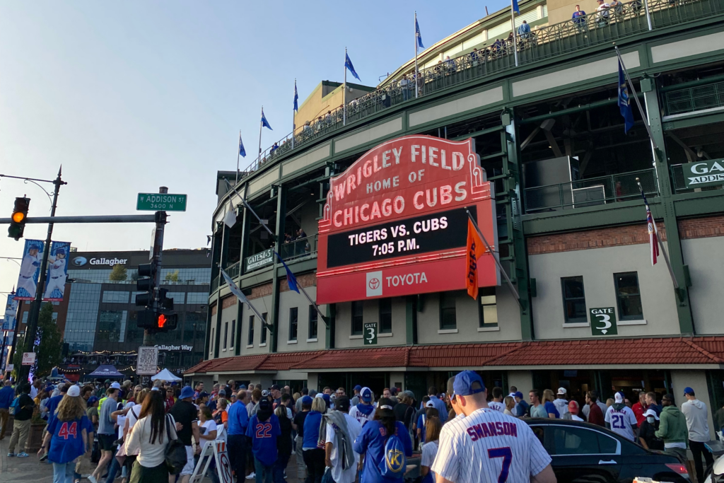 Marquee outside Wrigley Field with fans walking nearby